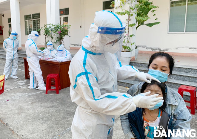 Residents living on/ near Ngo Xuan Thu Street in Hoa Hiep Bac Ward have their throat and nose swab samples taken for SARS-CoV-2 testing on Sunday. Photo: TRONG HUNG