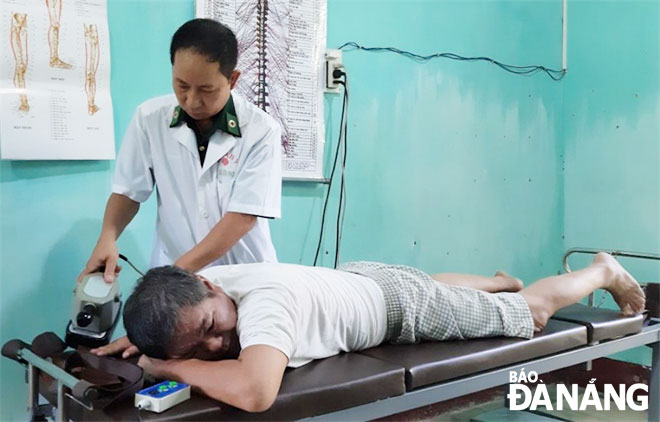 Thiếu tá Ninh Công Khánh khám, chữa bệnh giúp dân tại Khu dân cư văn hóa biển Kim Liên, phường Hòa Hiệp Bắc, quận Liên Chiểu. 	               Ảnh: NHƯ THẢO