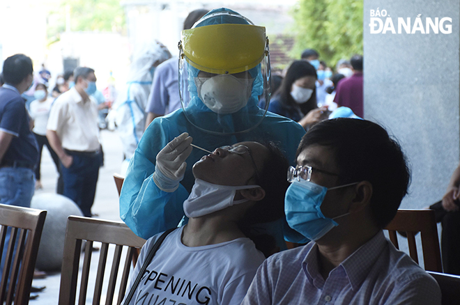 Medical workers collected a throat and nasal swab of all staff members at at the Da Nang Administrative Centre on Sunday morning