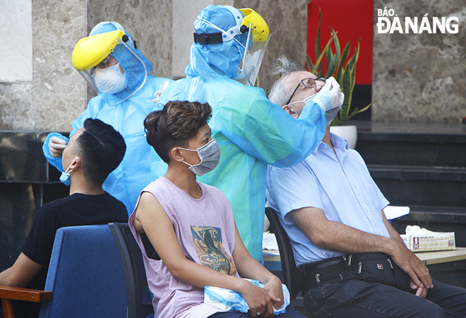 Nhân viên y tế quận Hải Châu lấy mẫu xét nghiệm SARS-CoV-2 cho người dân sinh sống tại chung cư FHome chiều 9-5. Ảnh: XUÂN DŨNG