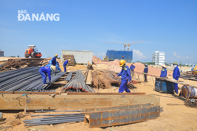 Enthusiastic working atmosphere is seen at the construction site of a street and a bridge spanning the Co Co River in Ngu Hanh Son District’s Hoa Hai Ward. Photo: THANH LAN