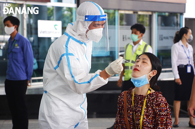 Nhân viên y tế của lấy mẫu cho người làm việc tại Cảng hàng không quốc tế Đà Nẵng sáng 11-5, Ảnh: XUÂN DŨNG