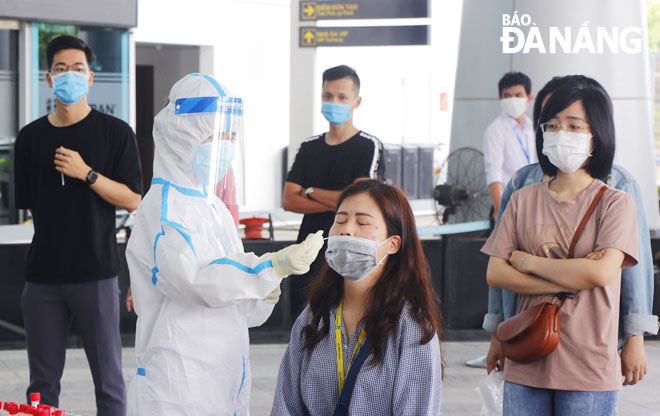 Cán bộ y tế Trung tâm Kiểm soát bệnh tật thành phố lấy mẫu xét nghiệm Covid-19 đối với những nhân viên làm việc tại Sân bay quốc tế Đà Nẵng.    Ảnh: XUÂN DŨNG