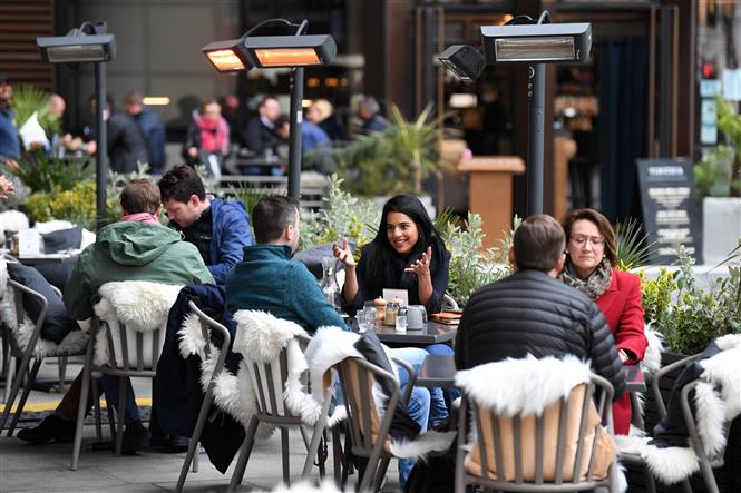 Người dân dùng bữa bên ngoài của một nhà hàng ở London, Anh ngày 29/4/2021. Ảnh: AFP/TTXVN