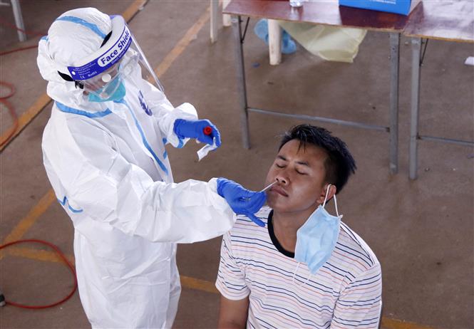 Bác sĩ đang lấy mẫu xét nghiệm cho một người dân Viêng Chăn tại một điểm xét nghiệm dã chiến. Ảnh: Phạm Kiên - Pv TTXVN tại Lào