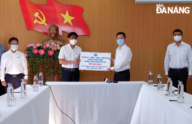 Bí thư Thành ủy Nguyễn Văn Quảng (thứ 2, phải sang) thưởng 100 triệu đồng cho quận Sơn Trà vì những nỗ lực phòng, chống, kiểm soát dịch bệnh Covid-19 trong thời gian qua. Ảnh: PHAN CHUNG