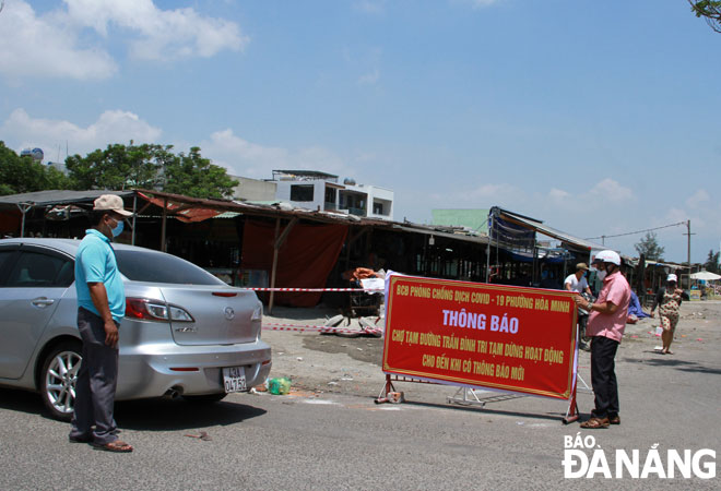 Functional forces were deployed at the temporary wet market on Tran Dinh Tri Street for the erection of closure notices which have come into effect from midday on May 14 until further notice.  Photo: TRONG HUNG