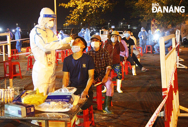 Trung tâm Y tế quận Sơn Trà tổ chức lấy mẫu xét nghiệm SARS-CoV-2 cho ngư dân, tiểu thương hoạt động tại cảng cá Thọ Quang và chợ đầu mối thủy sản đêm 14-5, rạng sáng 15-5. Ảnh: XUÂN DŨNG