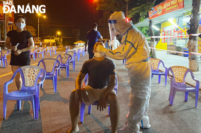 Lực lượng y tế làm việc xuyên đêm 11-5 để lấy mẫu xét nghiệm cho người lao động Khu công nghiệp Đà Nẵng. Ảnh: XUÂN DŨNG