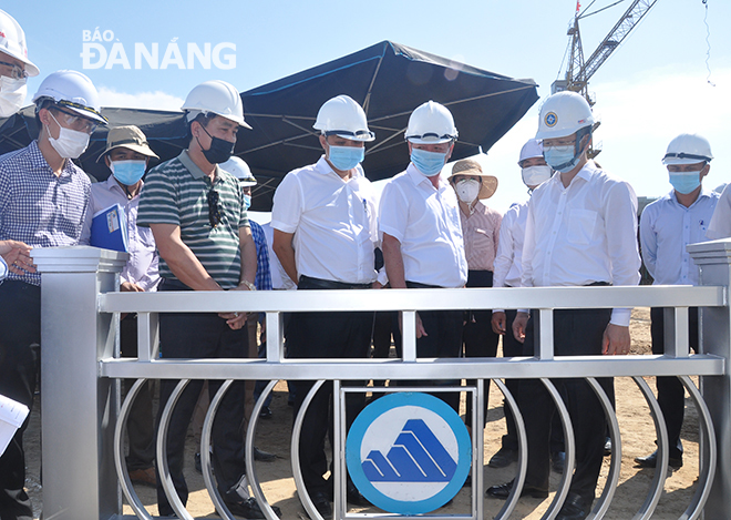 Da Nang Party Committee Secretary Nguyen Van Quang (second from right) listens to a technical report on the construction of a street and a bridge spanning the Co Co River on May 14. Photo: THANH LAN