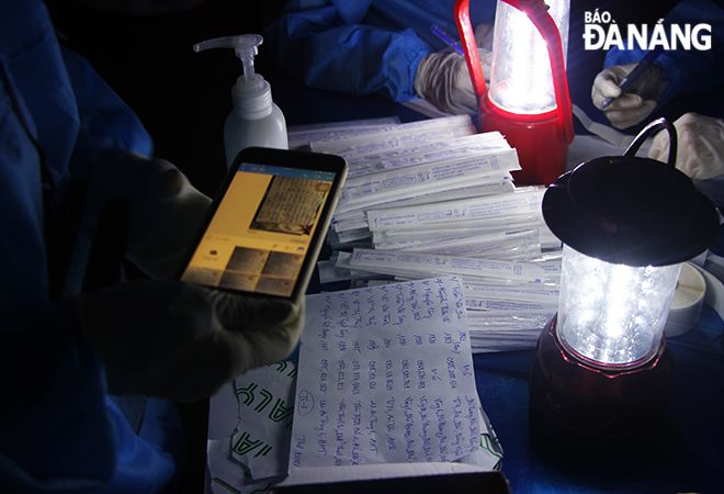 Medical workers pictured a list of the tested people to send to the Da Nang CDC prior to send their swab samples to this centre to test for the virus. Photo: XUAN DUNG