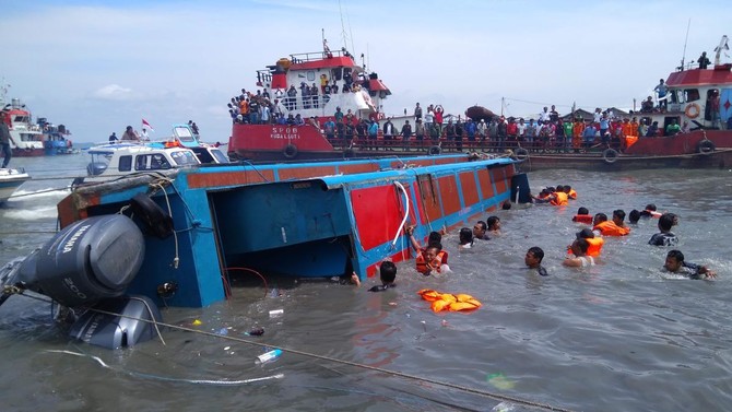 Các thành viên của đội tìm kiếm và cứu hộ Indonesia cố gắng giúp đỡ hành khách từ một chiếc thuyền bị lật ở Tarakan vào ngày 25/7/2017. Ảnh (tư liệu): AFP