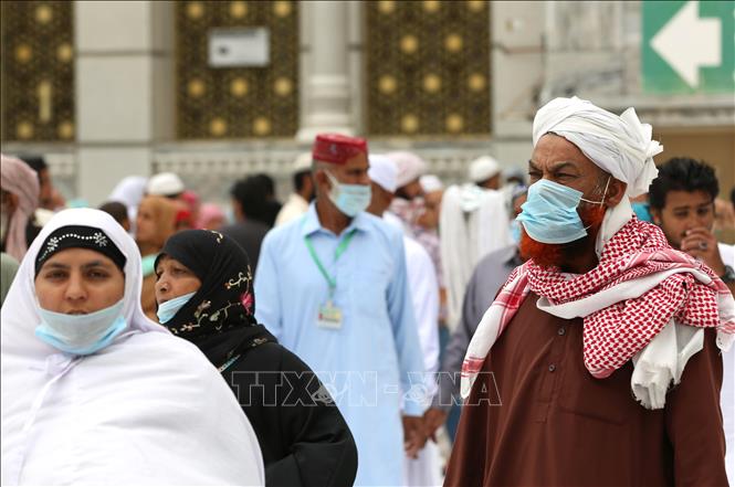 Người dân đeo khẩu trang phòng lây nhiễm Covid-19 tại Mecca, Saudi Arabia, ngày 13-3-2020. Ảnh: AFP/TTXVN