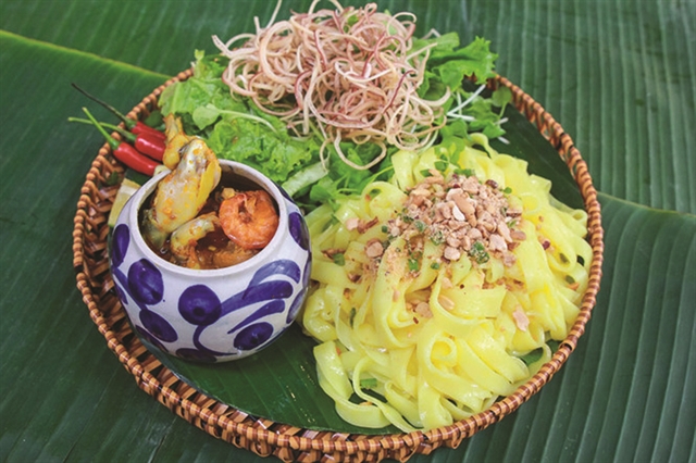 TOP CHOICE: The signature noodles served on a bamboo tray with a hotpot with two frog legs sticking out. Photo thanhnien.vn