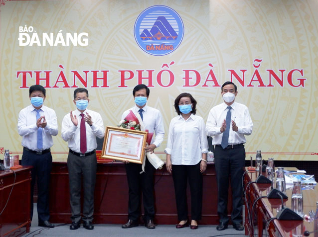 Lãnh đạo Thành ủy, UBND và Sở Y tế thừa ủy quyền tặng Bằng khen của Thủ tướng Chính phủ và chúc mừng CDC Đà Nẵng. Ảnh: PHAN CHUNG
