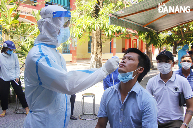 Nhân viên y tế quận Sơn Trà lấy mẫu xét nghiệm cho người dân tại phường Nại Hiên Đông. Ảnh: XUÂN DŨNG
