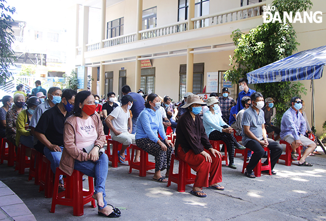 Người dân phường Nam Dương (quận Hải Châu) ngồi chờ đến lượt lấy mẫu xét nghiệm. Ảnh: XUÂN DŨNG
