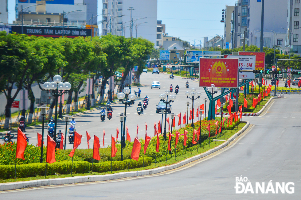 Red flags and flowers gave a new look to a section of Vo Van Kiet Street.