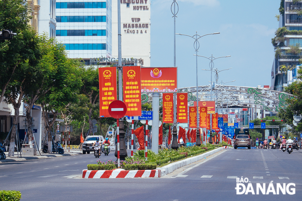   A section of Nguyen Van Linh Street is brightly adorned with flags, banners, panels and more.