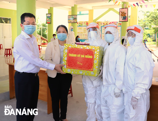 Bí thư Thành ủy Nguyễn Văn Quảng tặng quà cho tổ y tế đang làm nhiệm vụ xét nghiệm tại Trường Mầm non Hòa Phong cơ sở 2. Ảnh: NGỌC PHÚ