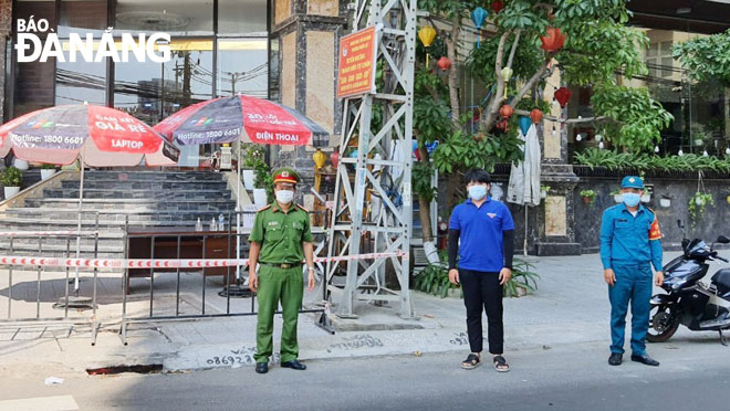 Dân quân thường trực quận Sơn Trà (bìa phải) phối hợp các lực lượng công an, thanh niên tình nguyện trực chốt tại một điểm cách ly trên địa bàn quận Sơn Trà. Ảnh: C.T