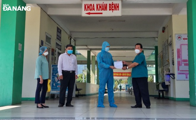 Doctor Le Thanh Phuc is seen handing over a discharge paper to the man who has been cleared of the novel coronavirus.