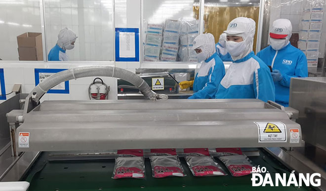 Công nhân thực hiện nghiêm túc quy định phòng, chống Covid-19 trong quá trình sản xuất tại Công ty CP Xuất nhập khẩu thủy sản miền Trung (quận Sơn Trà). 			 				                          Ảnh: KHÁNH HÒA