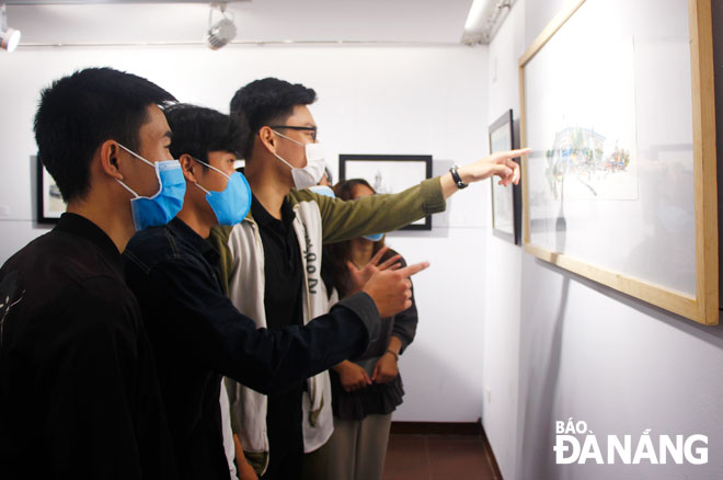 Da Nang students admire sketches on display at the ‘Da Nang after Its Liberation and Now’ exhibition at the Da Nang Fine Arts Museum