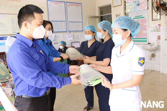 Đoàn viên, thanh niên thành phố trao mũ chống giọt bắn cho các y, bác sĩ ở Trạm Y tế phường Tam Thuận (quận Thanh Khê). Ảnh: THANH TÌNH