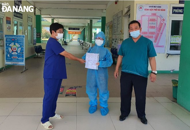 Leaders of the Da Nang Lung Hospital, handing a discharge paper to the completed-cured patient (middle)