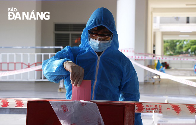 Police officers and medical workers staffing at the quarantine site in the western side of Da Nang cast their ballots. Photo: XUAN DUNG