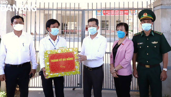 Bí thư Thành ủy Nguyễn Văn Quảng (giữa) tặng quà động viên lực lượng phục vụ bầu cử trong khu cách ly y tế tại ký túc xá phía tây, quận Liên Chiểu.												Ảnh: N.PHÚ