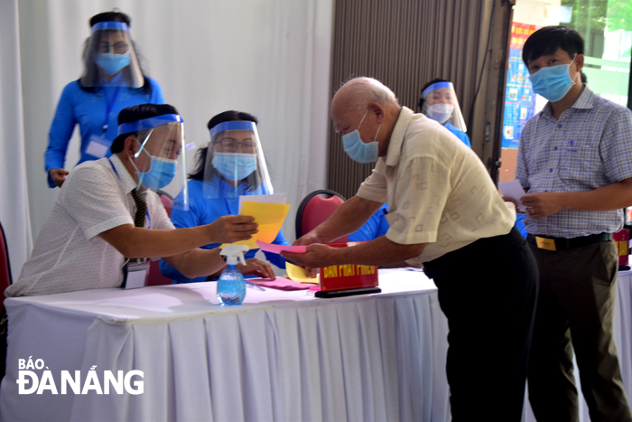 Members of Election Team No. 11 in Khue Trung Ward, Cam Le District guide a senior man to vote. Photo: TRONG HUY