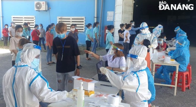 Employees working in the Hoa Cam Industrial Park have their nasal swab samples taken for COVID-19 testing, May 24, 2021. Photo: LE HUNG/ DNO