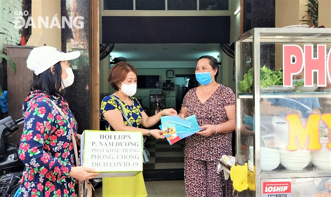 The members of Nam Duong Ward chapter of the municipal Women’s Union go from door to door so as to distribute facemasks and coronavirus information leaflets to residents. Photo: H.H