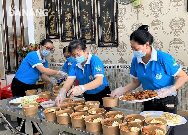 Members of Thuan Phuoc Ward chapter of the municipal Women’s Union prepare meals for frontline staff at the medical facility and quarantine checkpoints. Photo by H.H