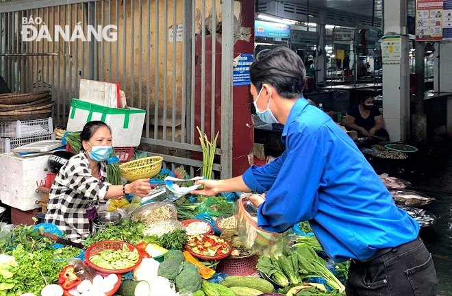 Youth union members of Hoa Thuan Dong ward distributed anti-droplet face shields to small traders at the market. Photo by H.H