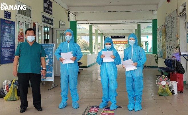 Bác sĩ Lê Thanh Phúc (ngoài cùng, bên trái) trao giấy xuất viện cho 3 bệnh nhân đã được điều trị khỏi Covid-19. Ảnh: L.HÙNG