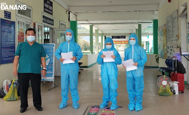 Doctor Le Thanh Phuc, Director of  the Da Nang Lung Hospital (first, left) hands discharge papers to the three completed-cured patients. Photo: L.HUNG