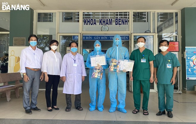 Leaders of the Hoa Vang District Medical Centre hand discharge papers to the two completed-cured patients (3rd, 4th, right). Photo: L.HUNG