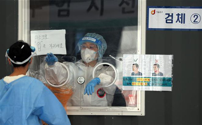 Nhân viên y tế lấy mẫu xét nghiệm Covid-19 tại Seoul, Hàn Quốc. Ảnh: YONHAP/TTXVN