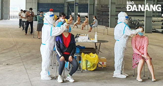 Cán bộ, nhân viên y tế lấy mẫu xét nghiệm cho người lao động làm việc tại Khu công nghiệp Hòa Khánh (quận Liên Chiểu) ngày 24-5. Ảnh: THIÊN DUYÊN