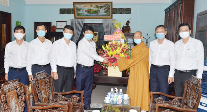 Deputy Secretary Triet (4th, left) presents flowers to a representative of the Buddhist Sangha