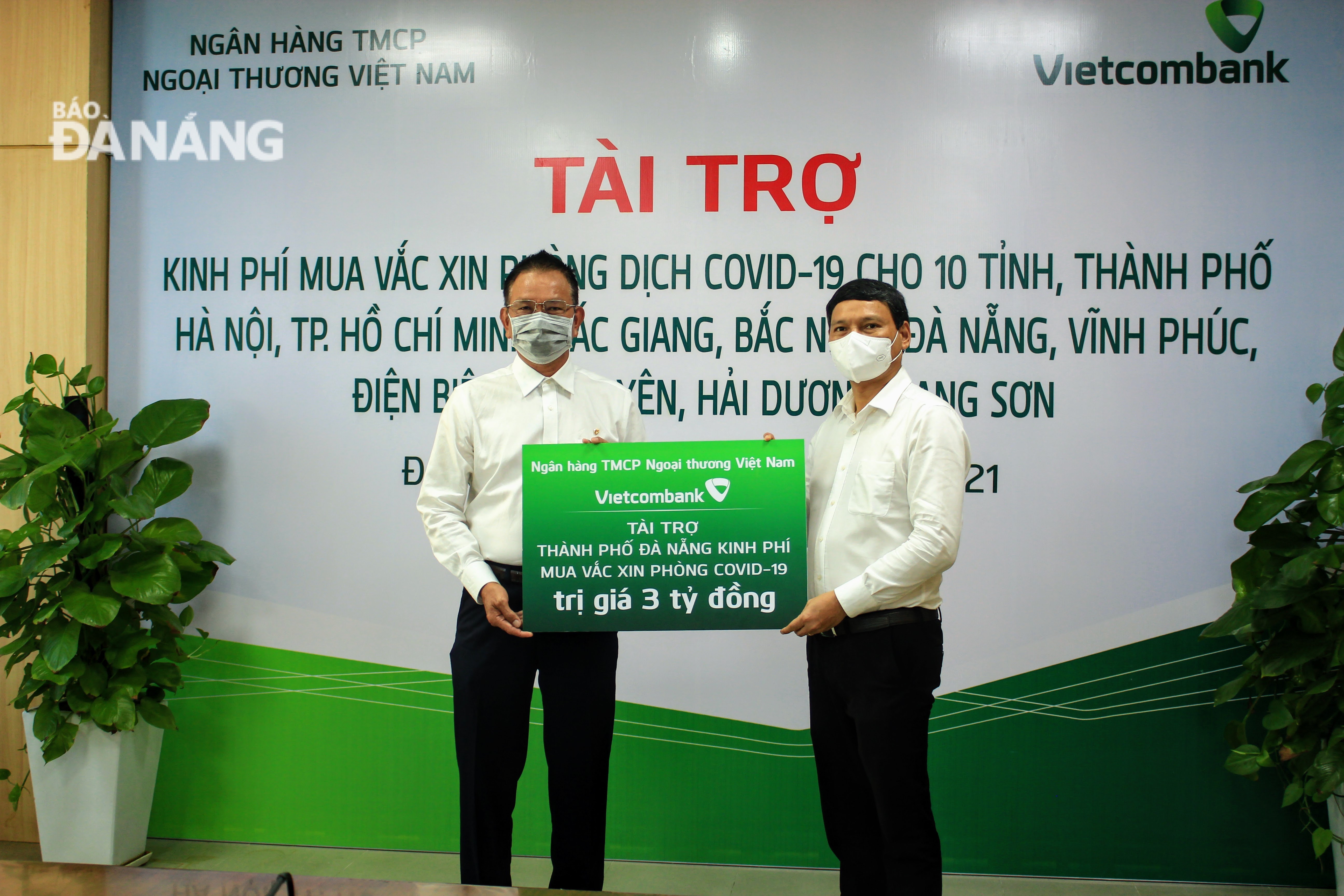 Da Nang People’s Committee Vice Chairman Ho Ky Minh (right) receives symbolic board of donations from a represtative of Vietcombank