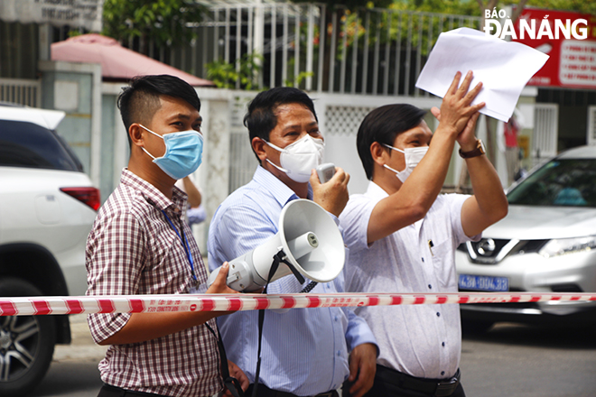 Son Tra District People's Committee Vice Chairman Huynh Van Hung (centre) announces the notice on lifting lockdown from the 12T3 apartment building on May 27, 2021. Photo: XUAN DUNG