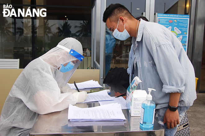 Nhân viên y tế quận Sơn Trà làm thủ tục cho công dân hoàn thành thời gian cách ly 21 ngày tại khách sạn Grand Tourane. Ảnh: XUÂN DŨNG