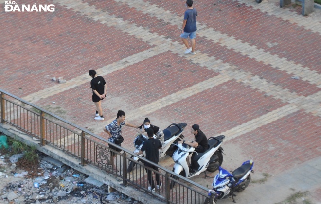 Nhóm thanh niên tụ tập tại vỉa hè đường Như Nguyệt (phường Thuận Phước) vào chiều 27-5 để nói chuyện, trong đó có người không đeo khẩu trang. Ảnh: LÊ HÙNG