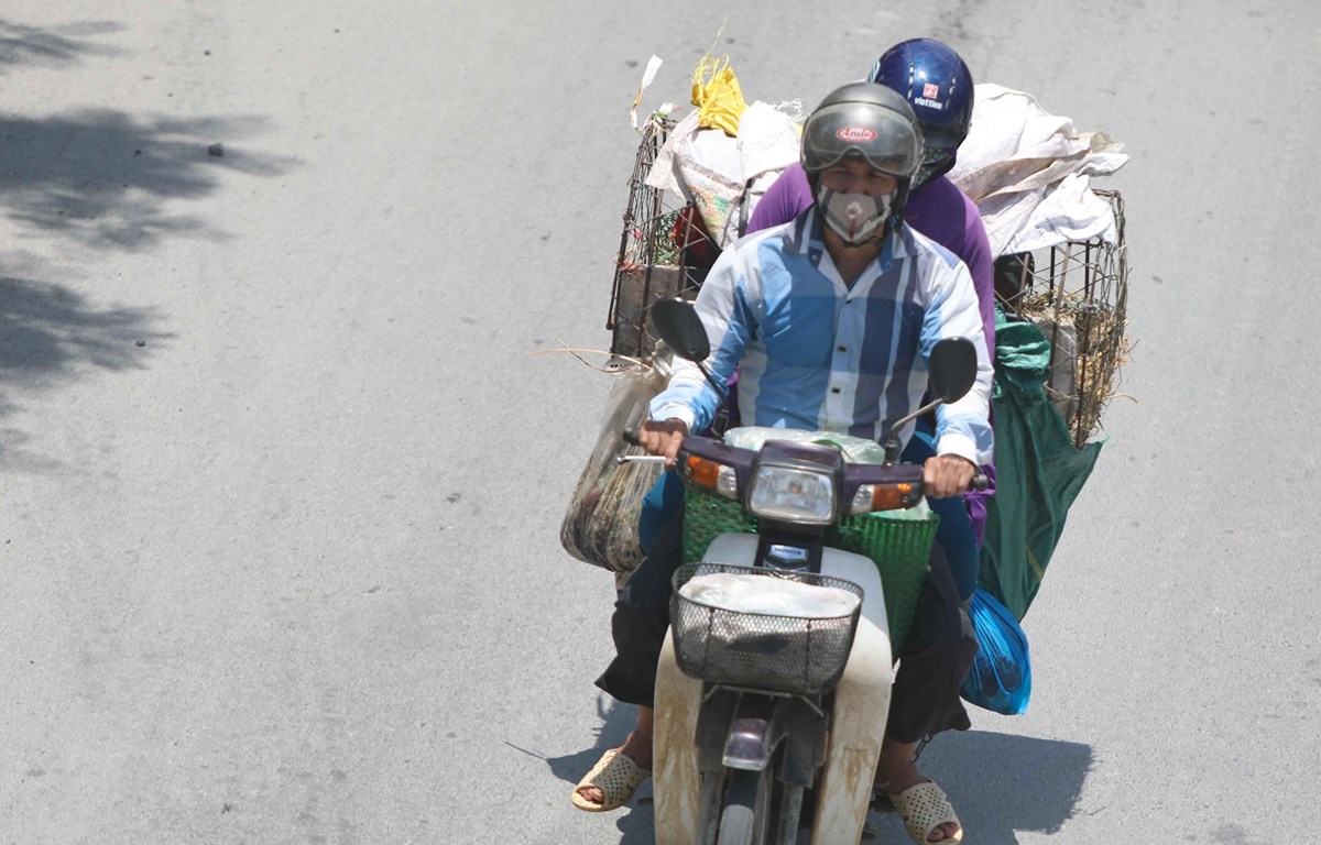 Thời điểm giữa trưa, nếu phải di chuyển trên đường, người dân cần trang bị đồ chống nắng để đảm bảo sức khỏe. (Ảnh: Thanh Tùng/TTXVN)