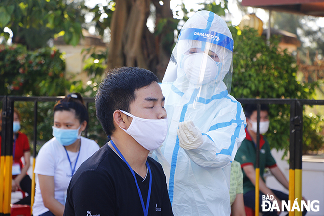 Medical workers take swab samples of employees working in the Da Nang IP to test for the virus. Photo: XUAN DUNG