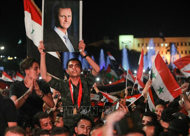 Người dân đổ xuống đường phố thủ đô Damascus, vui mừng khi kết quả bầu cử cho thấy Tổng thống Syria Bashar al-Assad tái đắc cử nhiệm kỳ thứ 4, ngày 27/5/2021. Ảnh: AFP/TTXVN